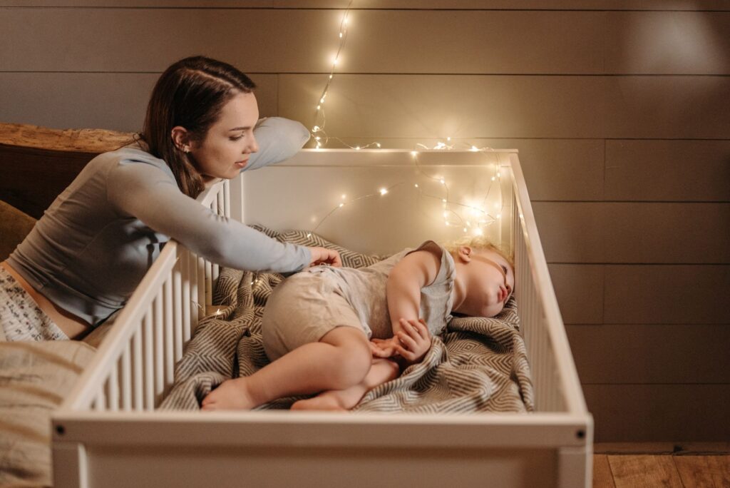 A tired parent watching over a baby monitor during a suspected sleep regression