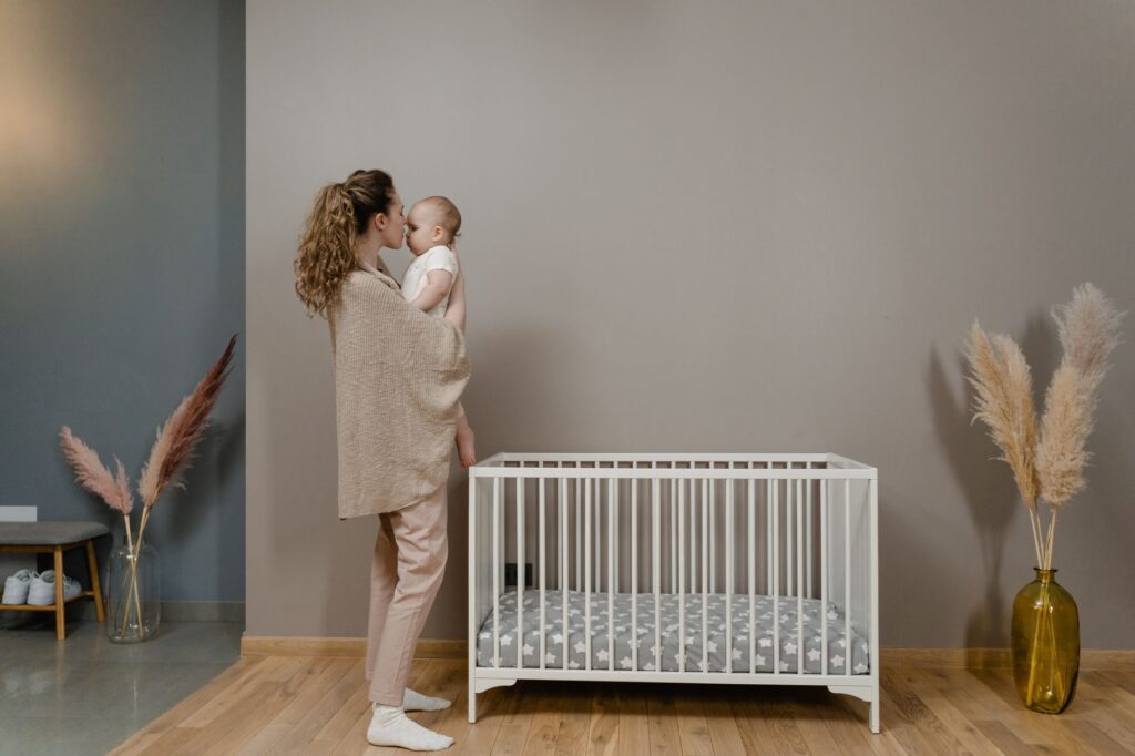 Mother gently comforting her baby in a dimly lit nursery